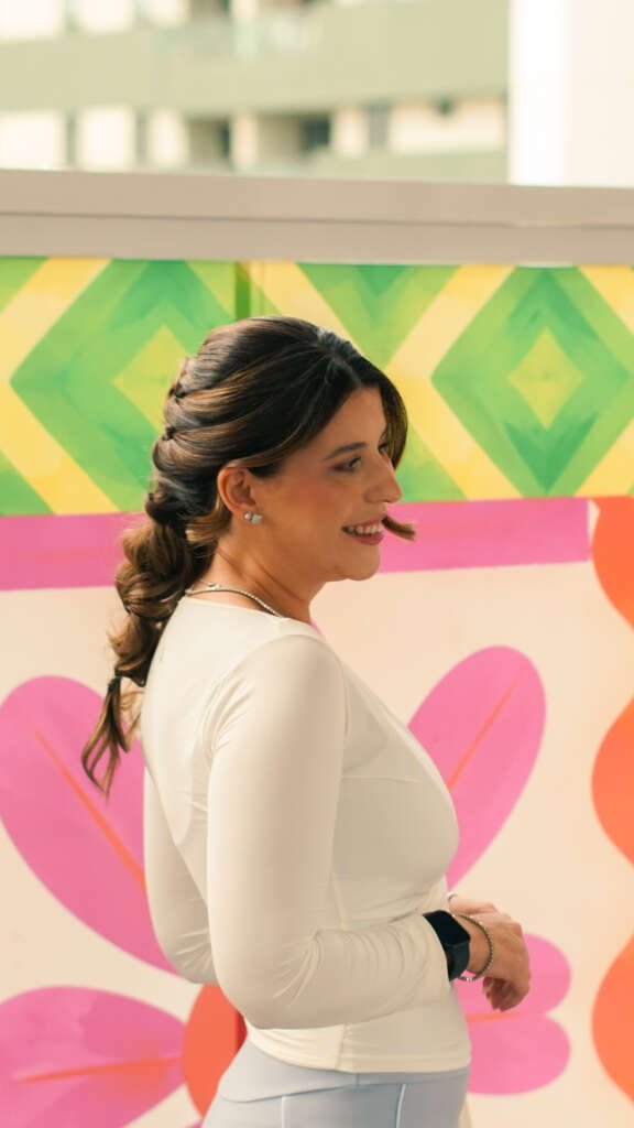 Participante do Catarina Summer 2026 em frente a painel decorativo colorido